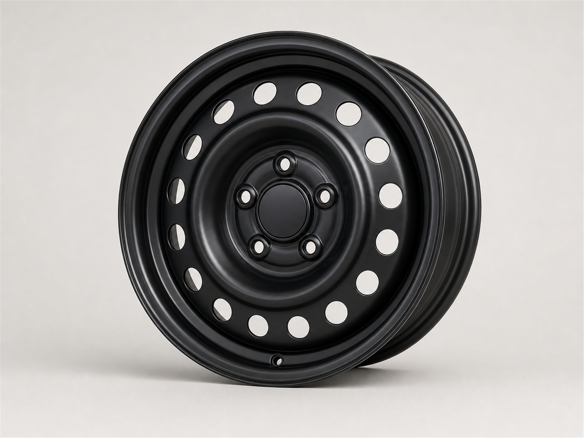 Unbranded black stamped steel automotive wheel with circular ventilation holes shown as a standalone studio product image on a light gray background.