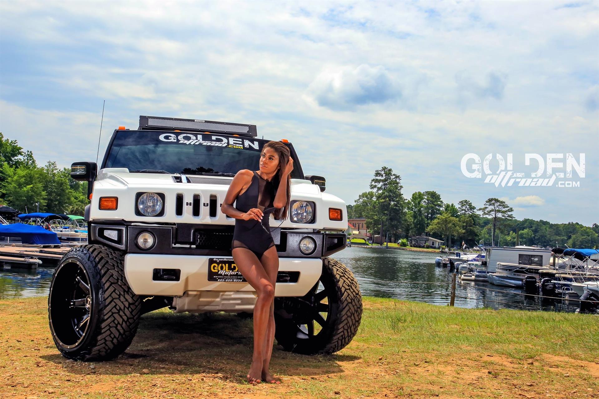 Female model standing in front of a truck with new wheels and tires